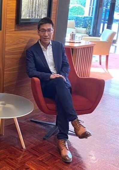 Photo of Dr Michael Chu sitting in a chair