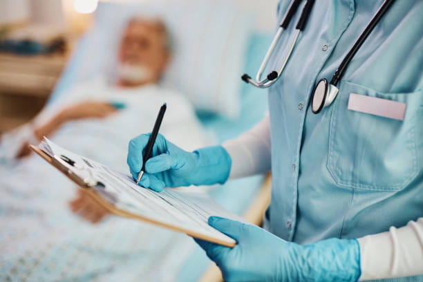 Close-Up of Nurse Writing Data Into Medical Record of Hospitalized Patient